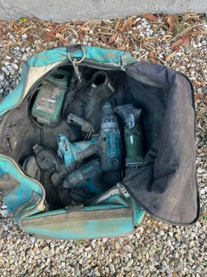 a bag full of tools sitting on the ground