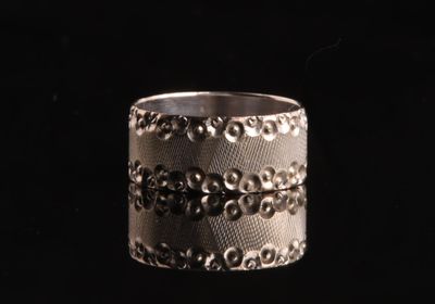 un gros plan d'une bague en argent sur fond noir