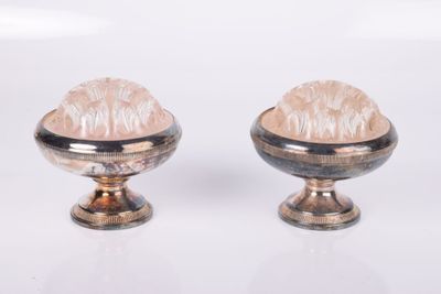 two silver vases that are sitting on a white surface