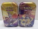 two tins of pokemon tins are sitting on a white surface