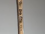 a close up of a spoon with a metal handle on a table