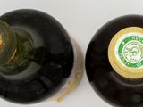 two bottles of wine sitting next to each other on a table