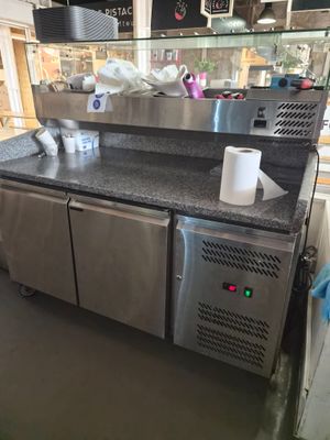 a stainless steel counter in a restaurant with cups of coffee on it