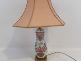 a lamp that is sitting on a table with a pink shade