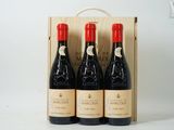 trois bouteilles de vin dans un coffret en bois sur une surface blanche