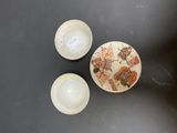 two bowls and a bowl with a picture on them sitting on a table