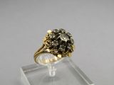 a close up of a gold ring with a black diamond on it