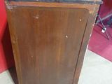 a small wooden cabinet with a door on top of it