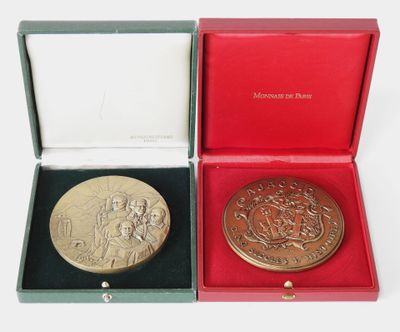 two gold medals in a red box on a white surface