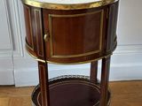 une table d'appoint ancienne avec un plateau en marbre posée sur un parquet