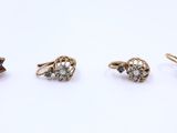 three pairs of gold and diamond stud earrings on a white surface