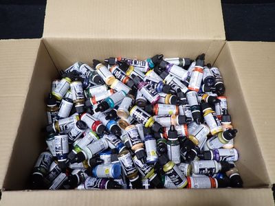 une boîte en carton remplie de pots de peinture de différentes couleurs