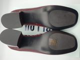 the bottom of a pair of black and red shoes on a white surface