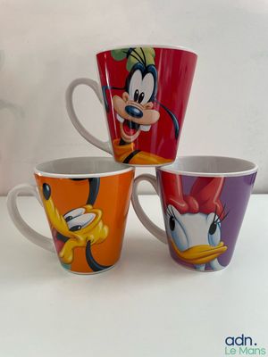 three disney mugs sitting on top of each other on a table