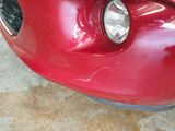 a close up of a red car with a cat on the hood