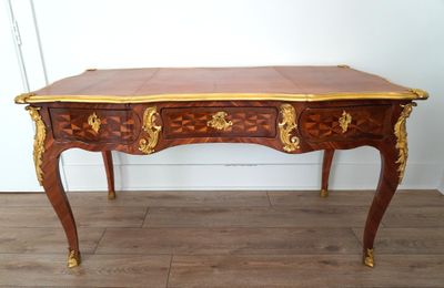 an image of a wooden desk with gold trimmings and drawers