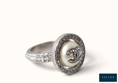 un gros plan d'une bague ornée d'une perle et de diamants