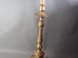 antique brass candle holder with a candle on top of it