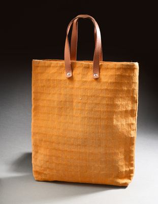 an orange tote bag sitting on top of a white table