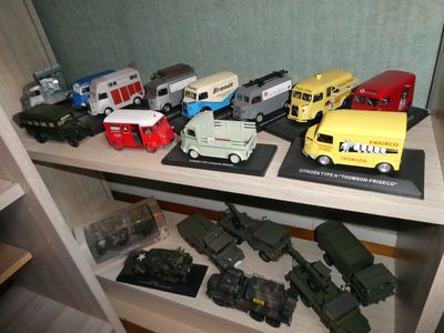many toy trucks and trucks on a shelf in a room