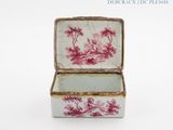 a small box with a painting on it sitting on a white surface