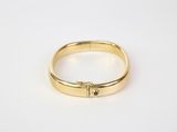 a close up of a gold ring on a white surface