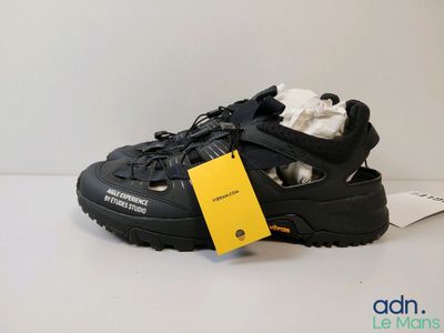 the shoe is black and has a yellow tag on it