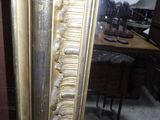 a mirror that has a gold frame on it