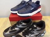 a pair of black and silver running shoes on top of a red box