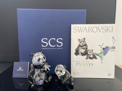 trois ours en argent posés sur une table, à côté d'un livre