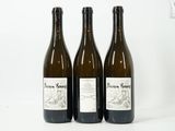 trois bouteilles de vin posées les unes à côté des autres sur une surface blanche