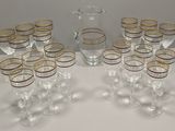 bottles and glasses are lined up on a table with a pitcher