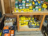 plusieurs boîtes de piles de différents types posées sur un établi