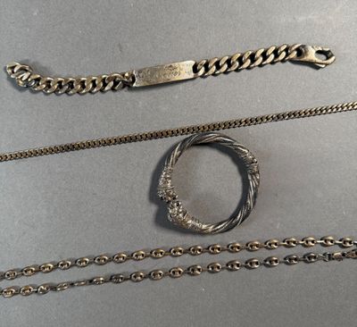 trois types de chaînes différents et un bracelet posés sur une table