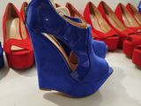 several pairs of blue and red high heeled shoes are lined up on a shelf