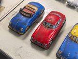 several toy cars are lined up on a table next to each other