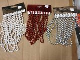 trois sachets de perles rouges et blanches sont posés sur une boîte en carton