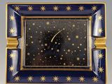 a blue and gold plate with a clock on it