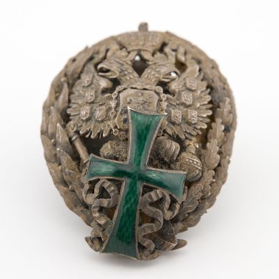 une vieille croix argentée et verte posée sur une boule