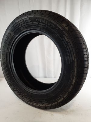 a close up of a tire on a white surface with a curtain in the background