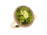 gros plan d'une bague avec une pierre verte entourée de diamants