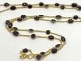 collier composé de perles de verre violettes et d'une chaîne plaquée or