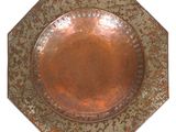 a copper plate with a design on it on a white background