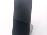 a black cell phone sitting on top of a stand