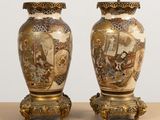 two vases are sitting on a table with a painting on them