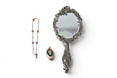 a mirror and a necklace on a white surface