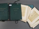 several books are lined up on a table with a bag
