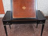 une table noire sur laquelle est posé un plateau en cuir marron