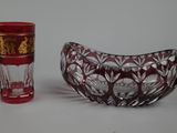 a red glass bowl and a red glass cup sitting next to each other