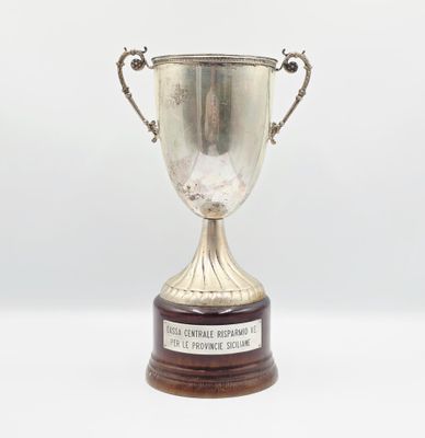 trophée en argent posé sur un socle en bois, sur fond blanc, avec un espace réservé au texte